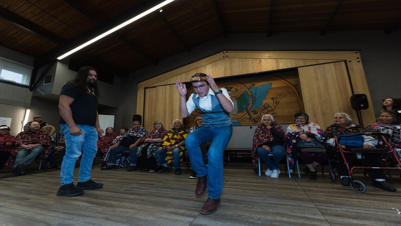 Timmy Masso, a Tla-o-qui-aht youth leader and Nuu-chah-nulth language champion, dancing surrounded by elders at the Nuu-chah-nulth language gathering in October 2018. (Photo by Melody Charlie)